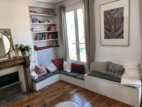 un soggiorno con divano e camino di Appartement Lombards 2 bedroom CityCosy a Parigi