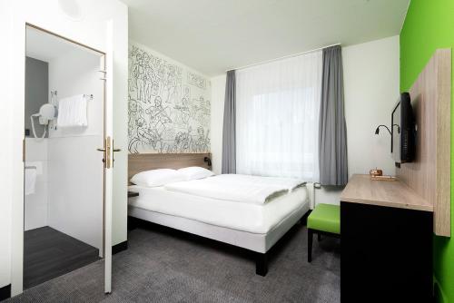 a bedroom with a white bed and a green wall at ibis Styles Halle in Halle an der Saale