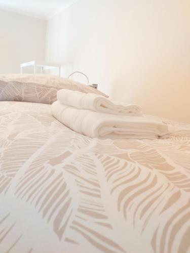 uma cama com duas toalhas brancas em cima em Made in You - Oporto Rooms no Porto