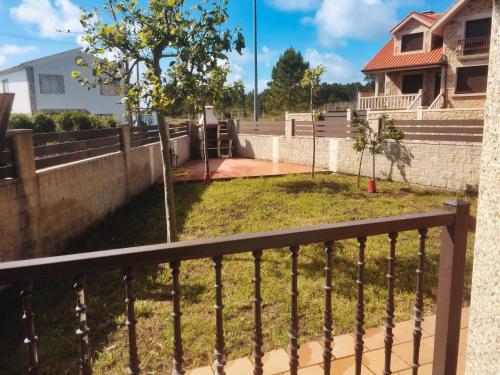 uitzicht op de tuin vanaf het balkon van een huis bij Apartamento Mirador de Corrubedo in Corrubedo