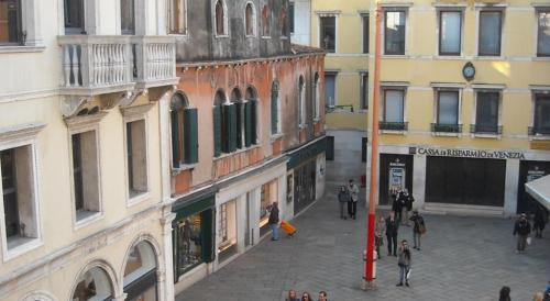 a group of people walking down a street next to buildings at Le Tango in Venice