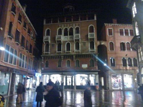 a group of people walking down a city street at night at Le Tango in Venice