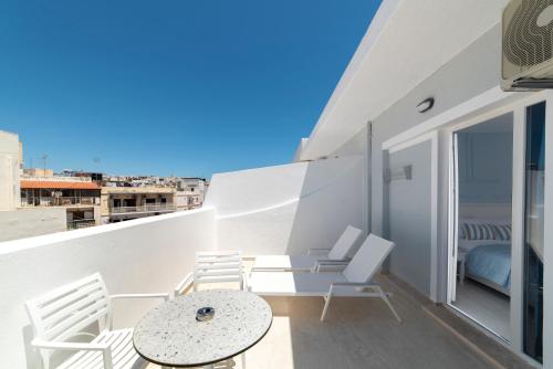 a balcony with a table and chairs on a building at Naiades Marina Hotel in Agios Nikolaos