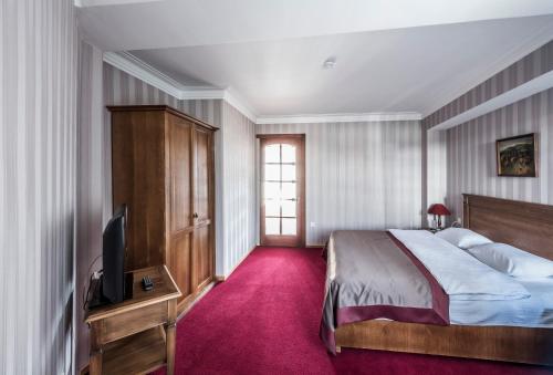 a bedroom with a bed and a tv on a table at Hotel Kopala in Tbilisi City