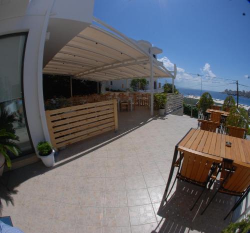 een patio met tafels en stoelen onder een paviljoen bij Hotel MS in Sarandë