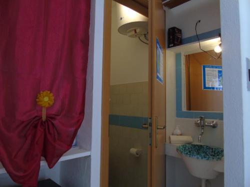 a bathroom with a sink and a toilet and a mirror at Villa Saracina in Vulcano