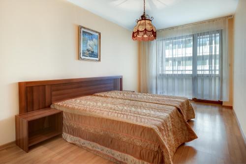 a bedroom with a bed and a large window at ДриймБг Апартаменти - Панорама Бийч, Несебър in Nesebar