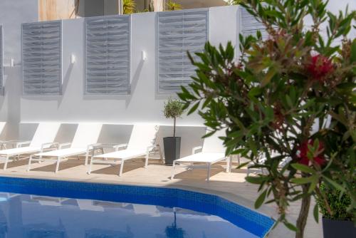 a group of chairs sitting next to a swimming pool at Naiades Marina Hotel in Agios Nikolaos