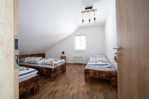 2 Einzelbetten in einem Zimmer mit Holzböden in der Unterkunft Penzion Šarlota & Vinařství Vítek Josef in Mutěnice