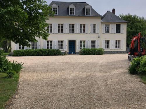 une grande maison blanche avec une grande allée. dans l'établissement Chambres D'hôtes le clos de la Bertinière petit déjeuner inclus, à Bosgouet