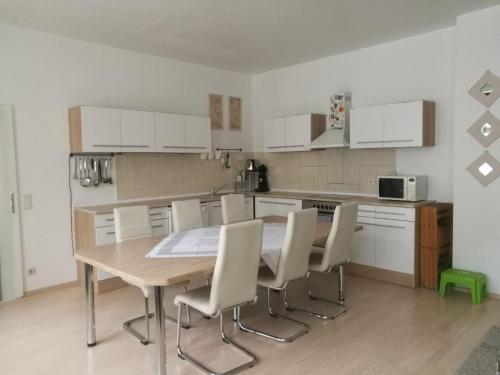 a kitchen with a wooden table and white cabinets at Ferienhaus Zoe 120 m2 in Solingen