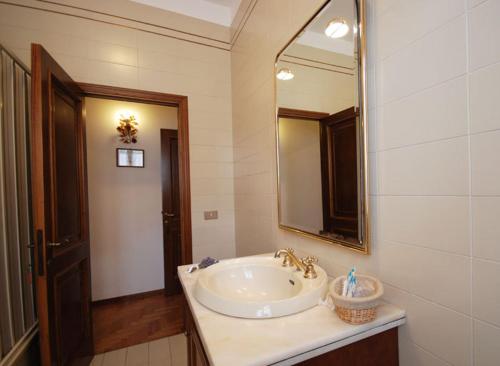 La salle de bains est pourvue d'un lavabo et d'un miroir. dans l'établissement Agriturismo La Sede Di Carlo, à Saturnia