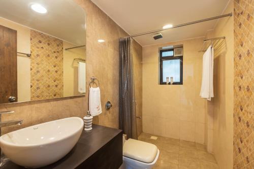 a bathroom with a sink and a toilet at SaffronStays Vedanta, Lonavala - villa with lawn, plunge pool and indoor games near Tungarli Lake in Lonavala