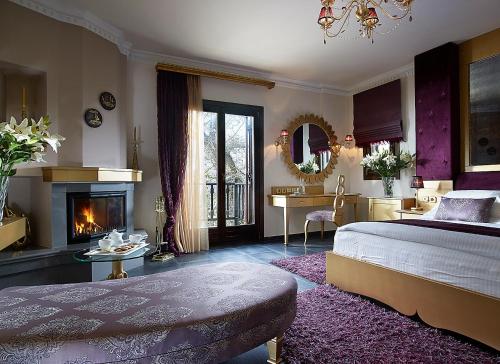 ein großes Schlafzimmer mit einem Bett und einem Kamin in der Unterkunft Stevalia Hotel & Spa in Portaria