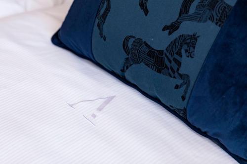 a zebra pattern on a blue pillow on a bed at Amadomus Luxury Suites in Naples