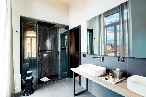 bagno con doccia in vetro e lavandino di Amadomus Luxury Suites a Napoli