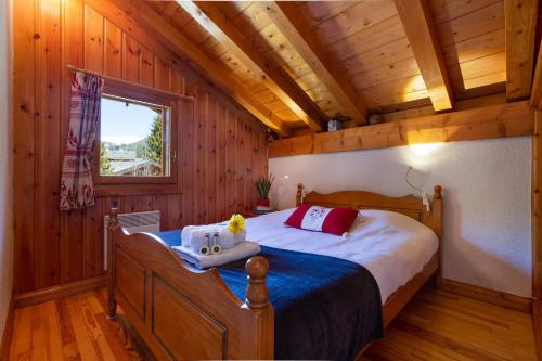 a bedroom with a bed in a wooden cabin at Village des Oursons Chalet B - Happy Rentals in Chamonix-Mont-Blanc