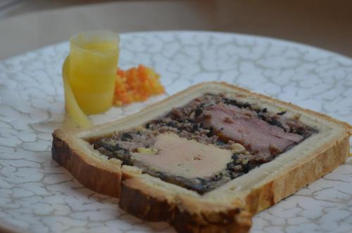 a plate with a piece of bread with meat and a drink at Hotel La Heid des Pairs in Spa