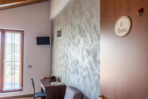 a room with a desk and a wall with a clock at B&B La Mortella in Albanella