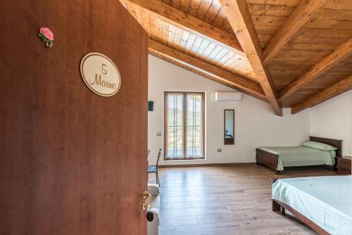 sypialnia z łóżkiem i drewnianym sufitem w obiekcie B&B La Mortella w mieście Albanella