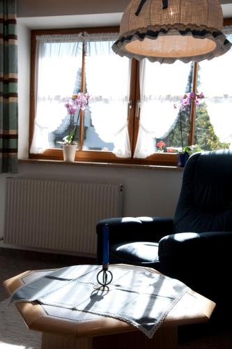a living room with a table and two chairs and windows at Landhaus Manuela & Haus Michael in Leutasch