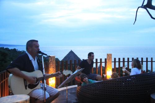 a group of people playing music and guitar on a deck at The Griya Villas and Spa in Amed