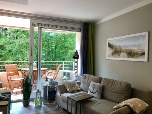 a living room with a couch and a large window at Appartement Gluecksanker in Glücksburg