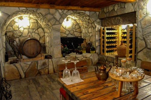 a wine tasting room with a large stone wall at Prevalis Nature Cottage in Virpazar