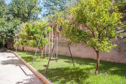 a swing set in the grass next to a tree at B&B La Mortella in Albanella