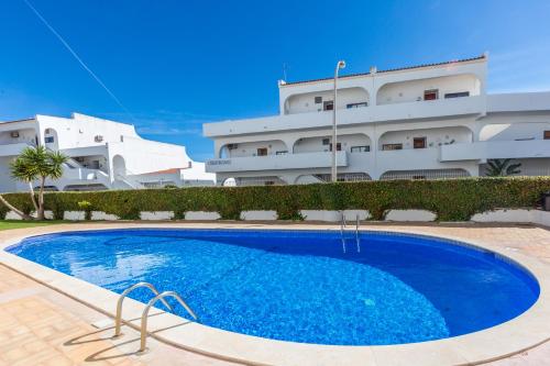 a large blue swimming pool in front of a building at Apartamento Correia in Albufeira