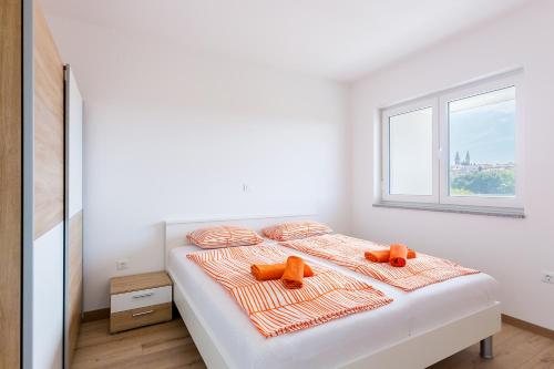 a white bedroom with a bed with two teddy bears on it at Apartment SALE EL SOL in Medulin