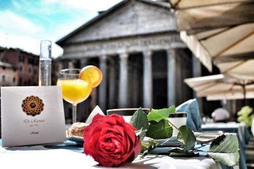 a table with a red rose and a glass of orange juice at Di Rienzo Pantheon Palace in Rome