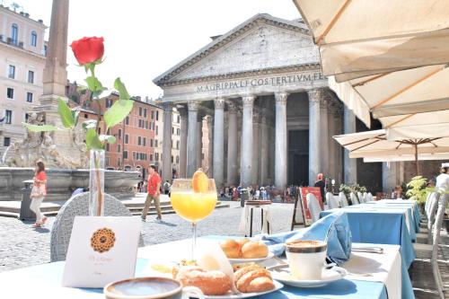 a table with food and a glass of orange juice at Di Rienzo Pantheon Palace in Rome