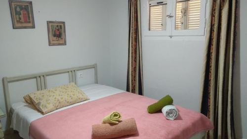 奧林匹亞的住宿－Mallios Country house near Ancient Olympia，一间卧室配有一张带粉色毯子的床