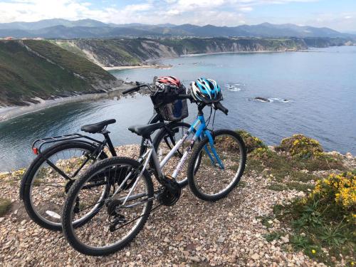 two bikes parked on a rocky hill next to the water at Apartamentos rurales la Aguilera in Oviñana