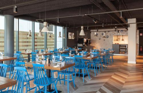 a dining room with blue chairs and tables at Best Western Plus Hotel Amstelveen in Amstelveen