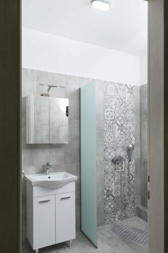 a bathroom with a white sink and a shower at Thalassoresort DOWNSTAIRS in Matala