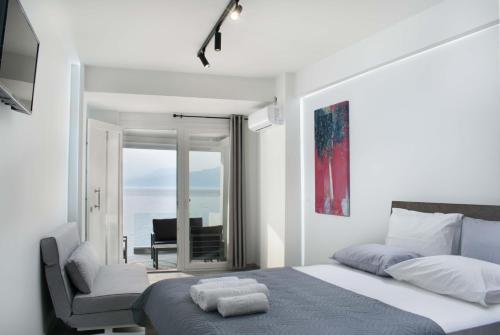 a bedroom with a bed with a chair and a window at Thalassoresort DOWNSTAIRS in Matala