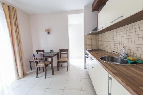 a kitchen with a sink and a table at Apartments Ameda in Vilnius