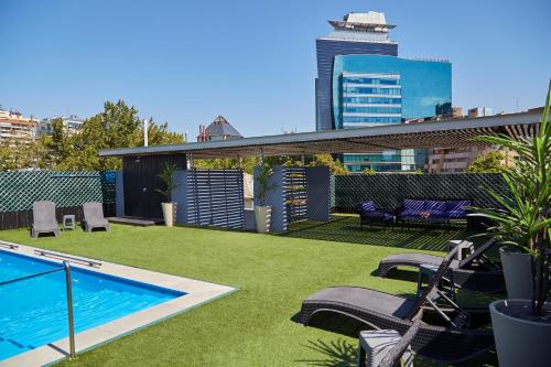 a large swimming pool in a grassy area at Hotel Torremayor Lyon in Santiago