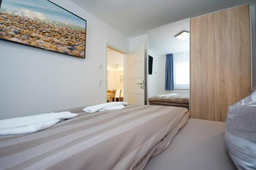 1 dormitorio con 1 cama con una pintura en la pared en Haus Meeresleuchten mit Sauna- und Erlebnisbadnutzung, en Ostseebad Sellin