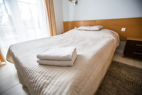 a bedroom with a bed with two towels on it at Apartments Ameda in Vilnius