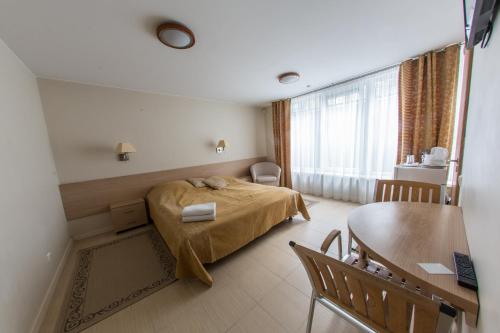 Apartments Ameda في فيلنيوس: غرفة نوم فيها سرير وطاولة فيها