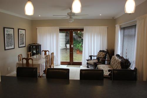 a dining room with a white table and chairs at MeTime Guesthouse & Self catering in Hartenbos