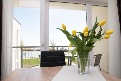 een vaas met gele tulpen op een tafel bij Akvárium Apartmanházak in Keszthely