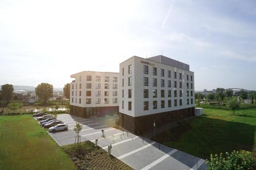 an aerial view of a building with cars parked in a parking lot at HARBR. hotel Heilbronn in Heilbronn