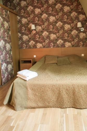 a bedroom with a bed with a floral wallpaper at Apartments Ameda in Vilnius