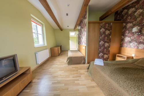 a room with a bed and a flat screen tv at Apartments Ameda in Vilnius