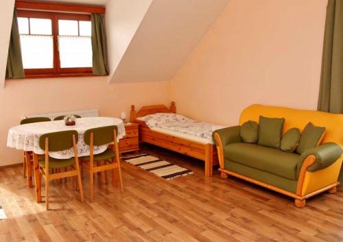 Habitación con cama, mesa y sillas. en Határ Csárda Panzió, en Bajánsenye