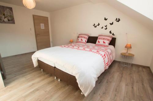 a bedroom with a bed with birds on the wall at Le Divin Gîte Classé 4 étoiles in Hunawihr